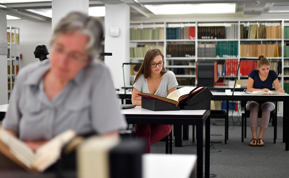 Das Bild zeigt Nutzerinnen, die an den Arbeitsplätzen im Lesesaal Sammlungen der Badischen Landesbibliothek an historischen Originalwerken forschen. 