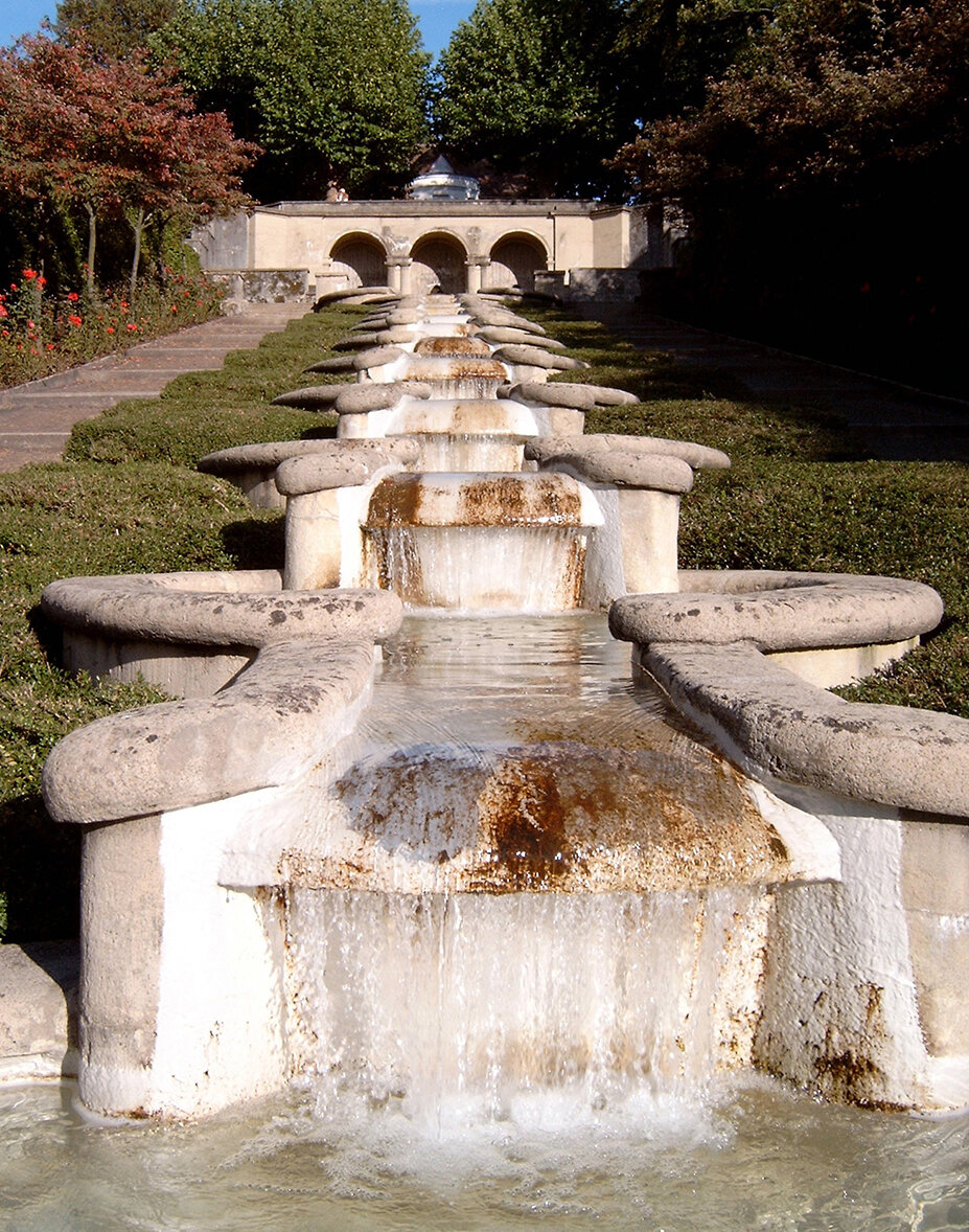 Zu sehen ist die von Max Laeuger entworfene Wasserkunstanlage Paradies in Baden-Baden. Man schaut von unten her über mehrere Stufen der Anlage nach oben. 