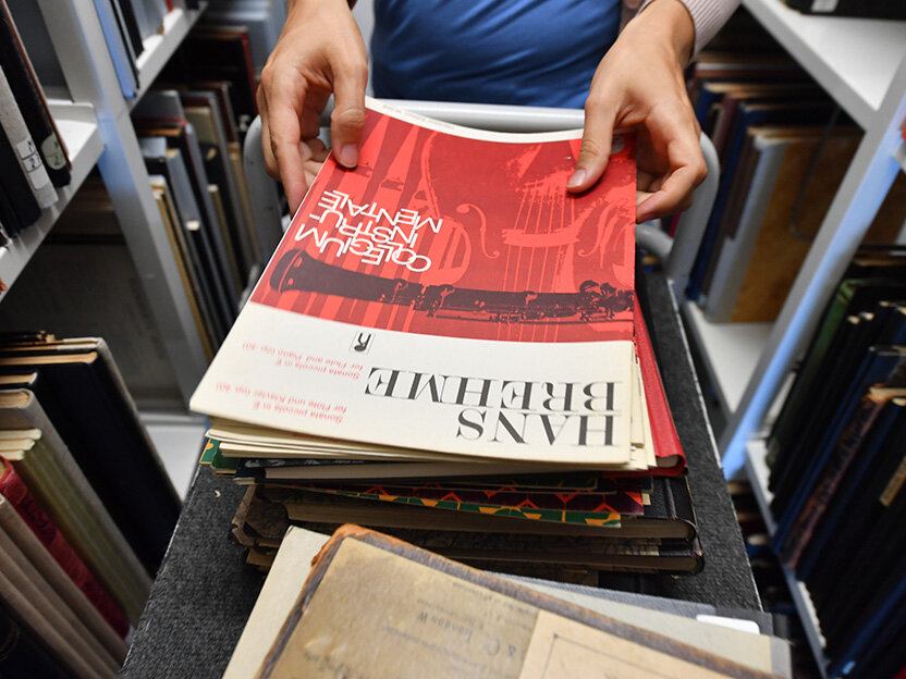 Zu sehen ist das Noten-Magazin der Badischen Landesbibliothek, wo gerade ein Notenheft von Hans Brehme entnommen wird.