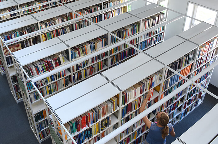 Das Bild zeigt eine Ansicht zahlreicher Bücherregale innerhalb der BLB. Die Aufnahme wurde von einem höher gelegenen Standpunkt aus angefertigt. 