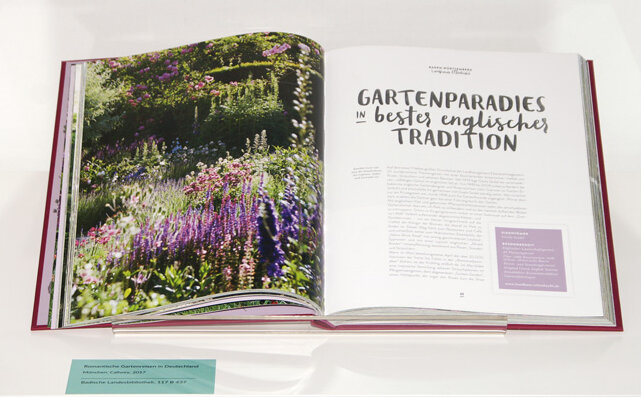 Ausgestellt eine Doppelseite aus "Romantische Gartenreisen in Deutschland" mit blühenden englischen Gärten.