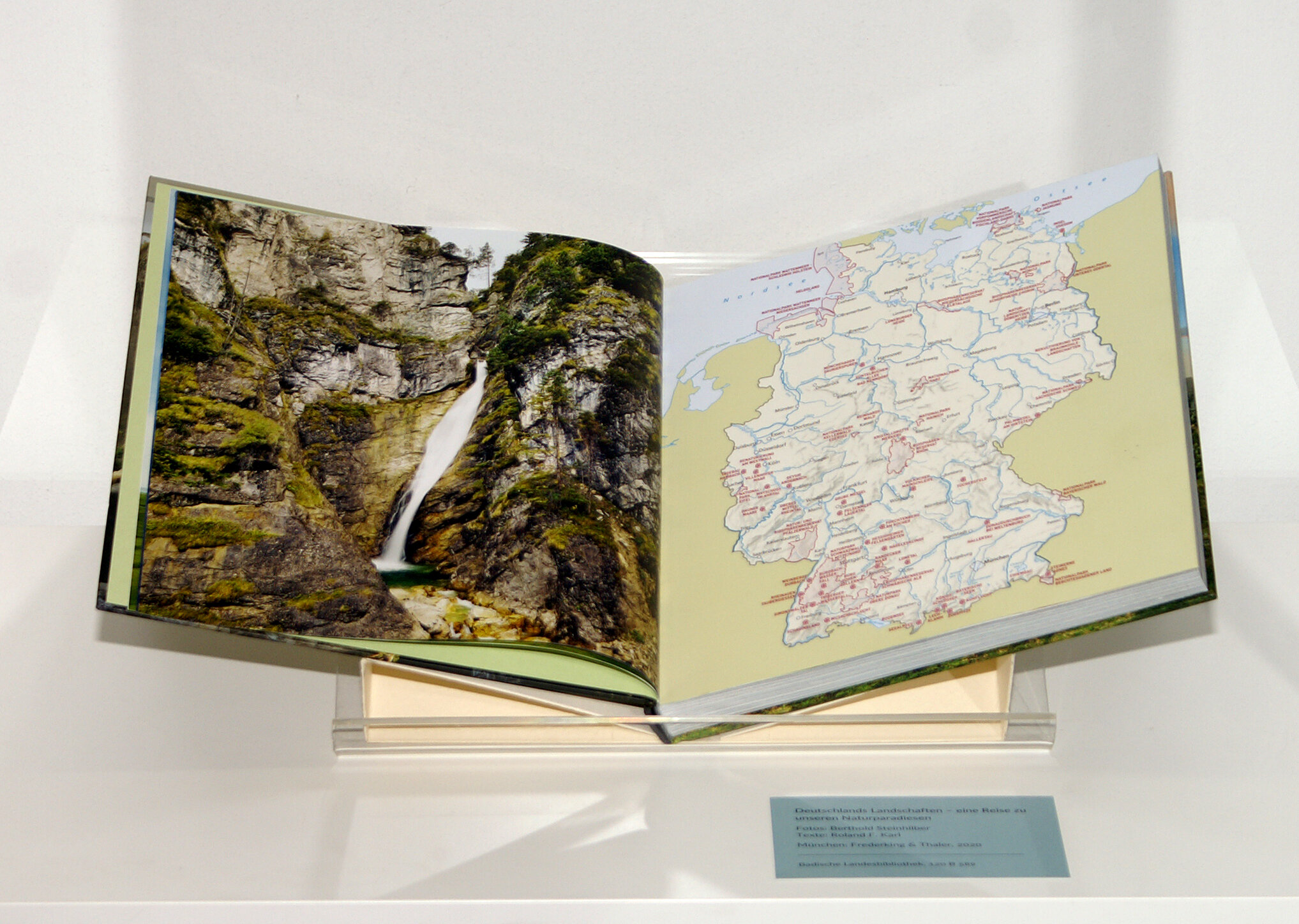 Doppelseite aus "Deutschlands Landschaften – eine Reise zu unseren Naturparadiesen", abgebildet links ist ein grün bewachsener Wasserfall, rechts eine Karte von Deutschland.