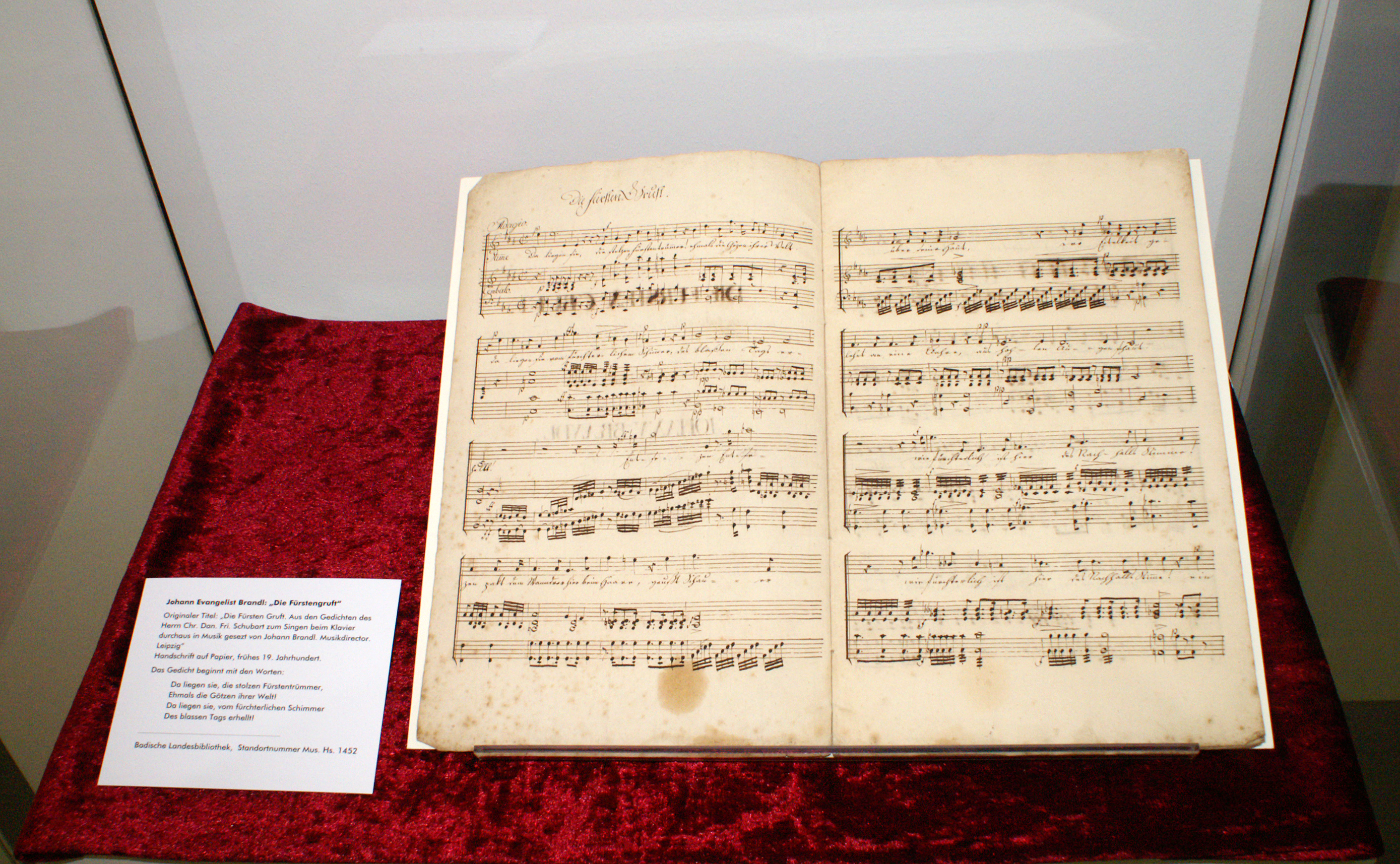 Ausstellungsansicht der Noten von Brandls Vertonung des Gedichts "Die Fürstengruft". Die Vitrine ist mit rotem Samt ausgelegt.