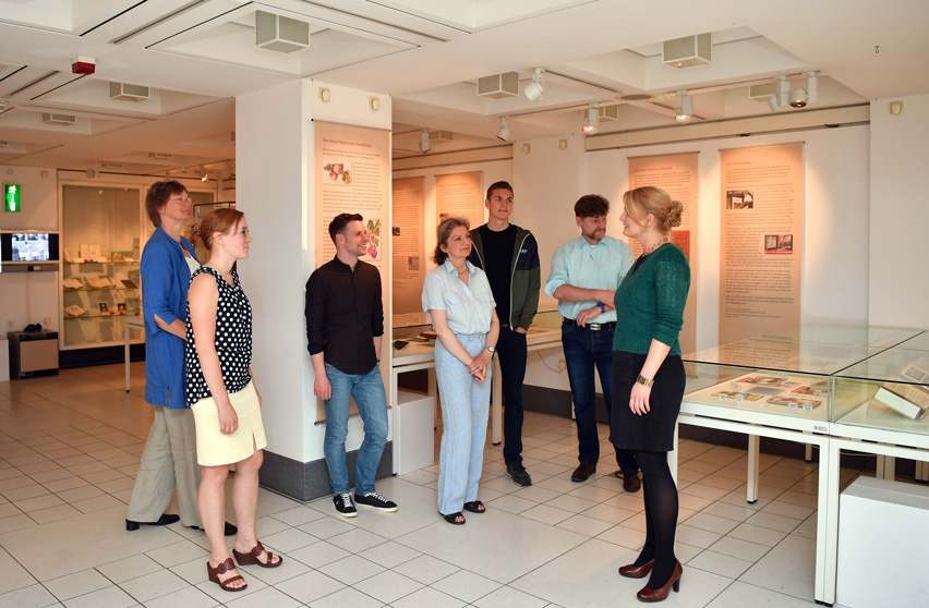 Das Bild zeigt eine Besuchergruppe im Ausstellungsraum der Badischen Landesbibliothek bei einer Führung.