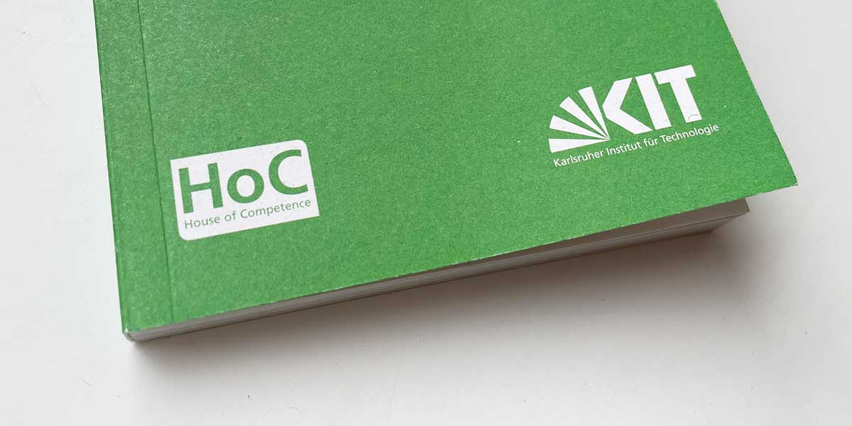 Grüne Broschüre, auf der das Logo des House of Competence und das KIT-Logo zu sehen sind.