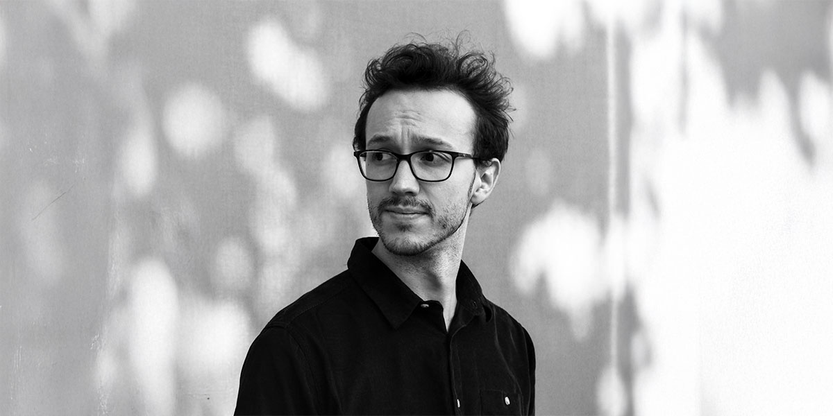 Zu sehen ist ein fotografisches Schwarzweiß-Portrait von Moritz Konrad.