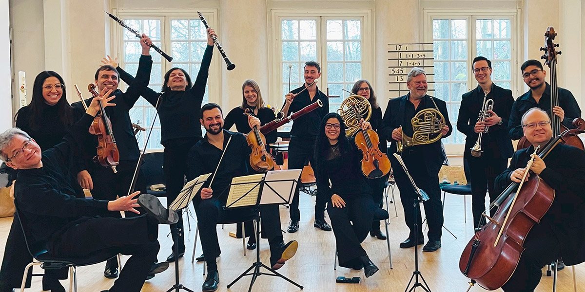 Zu sehen ist ein dynamisches Gruppenbild des BuschKollegiums Karlsruhe. Die Musikerinnen und Musiker halten Ihre Instrumente in den Händen.