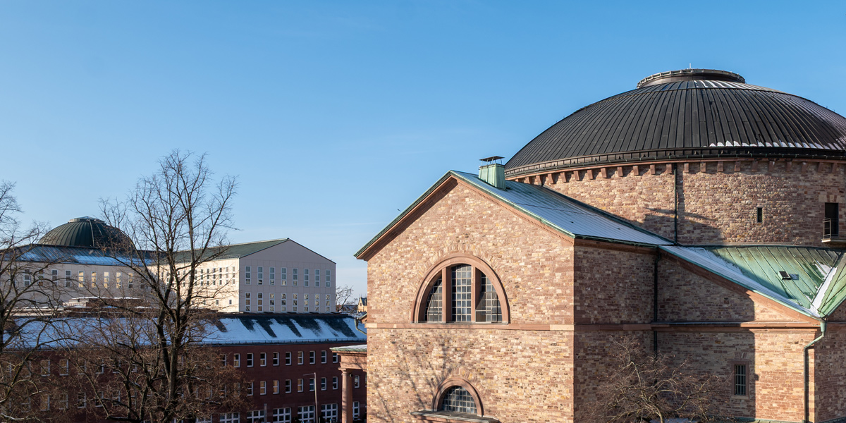 Zu sehen ist links das Bibliotheksgebäude mit der Lesesaalkuppel und rechts die Kuppel der Kirche St. Stephan.