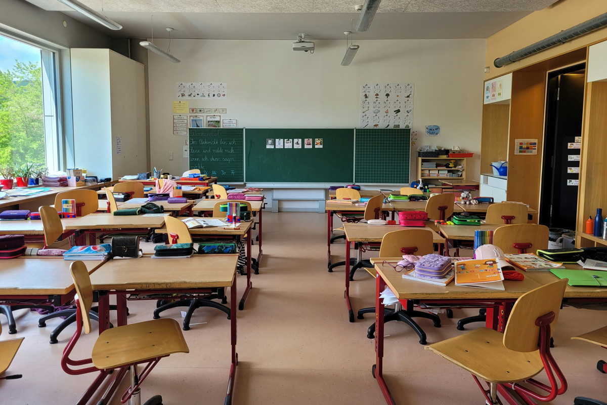 Zu sehen ist ein Klassenzimmer einer Grundschule, die Kinder sind in der Pause.