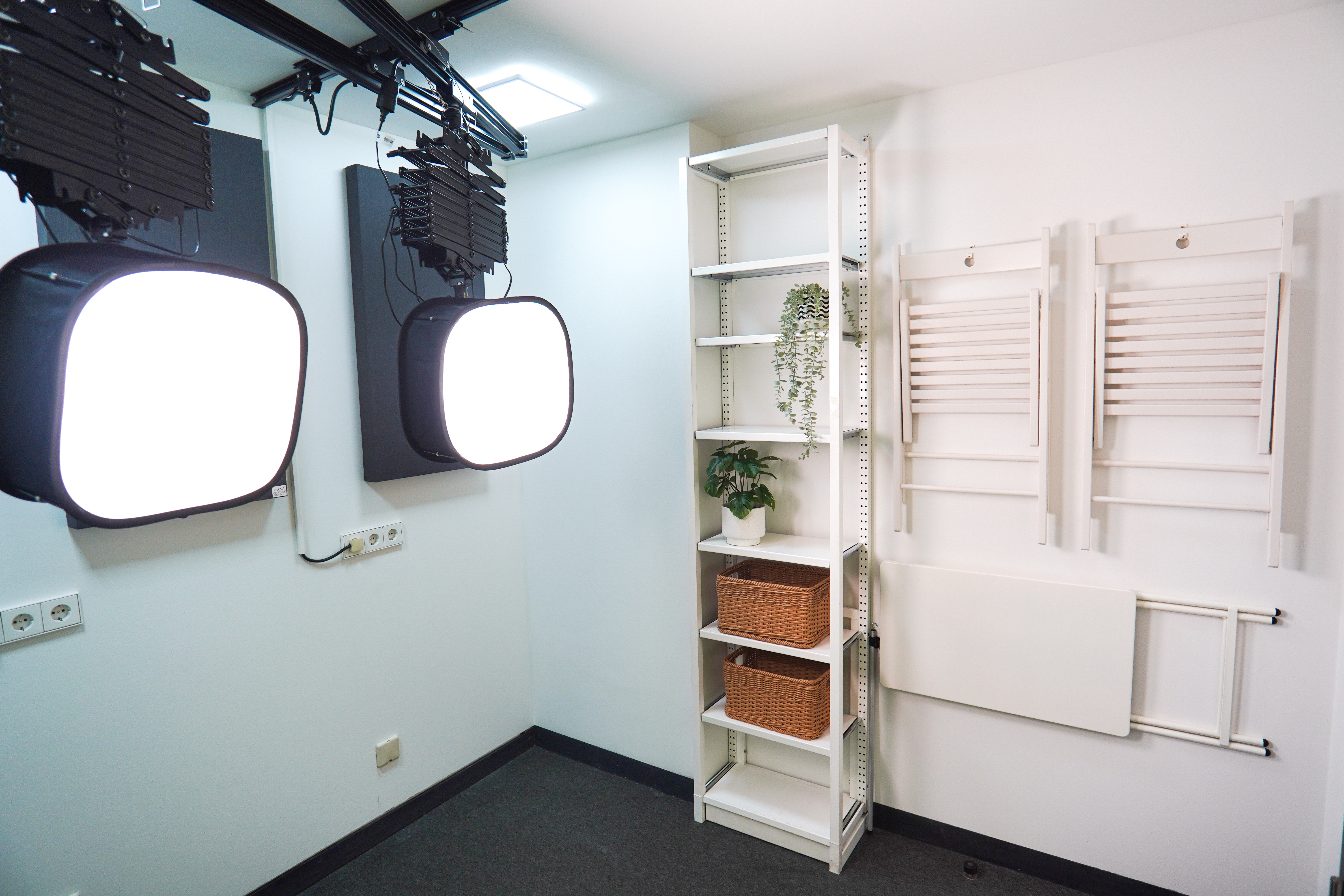 Zu sehen ist die Ausstattung des Media Studios der Lernwerkstatt, wie professionelle Beleuchtung, Stühle und Requisiten. 