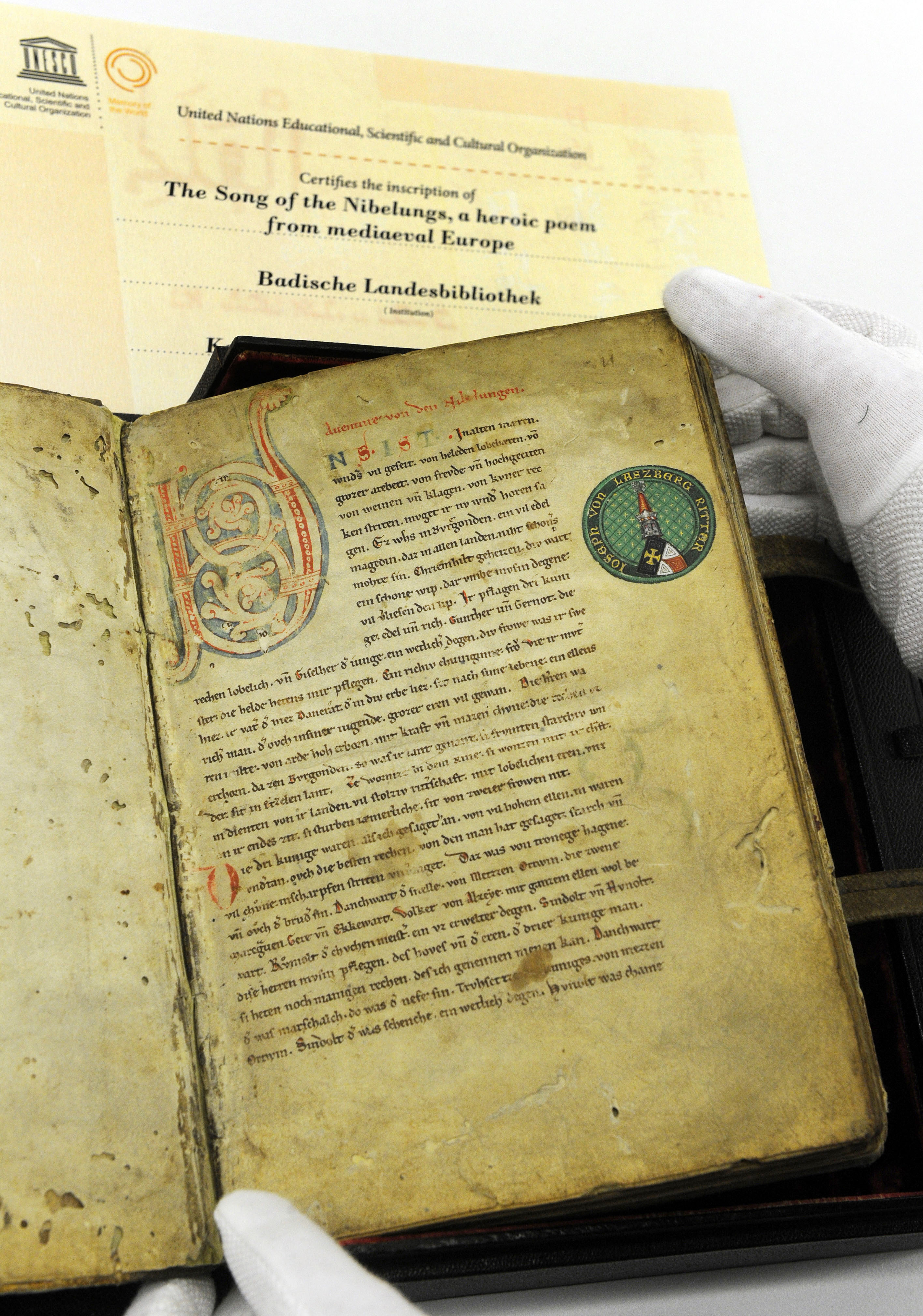 Zu sehen ist die erste Seite der Nibelungenliedhandschrift C mit dem Wappenexlibris des Joseph von Laßberg.
