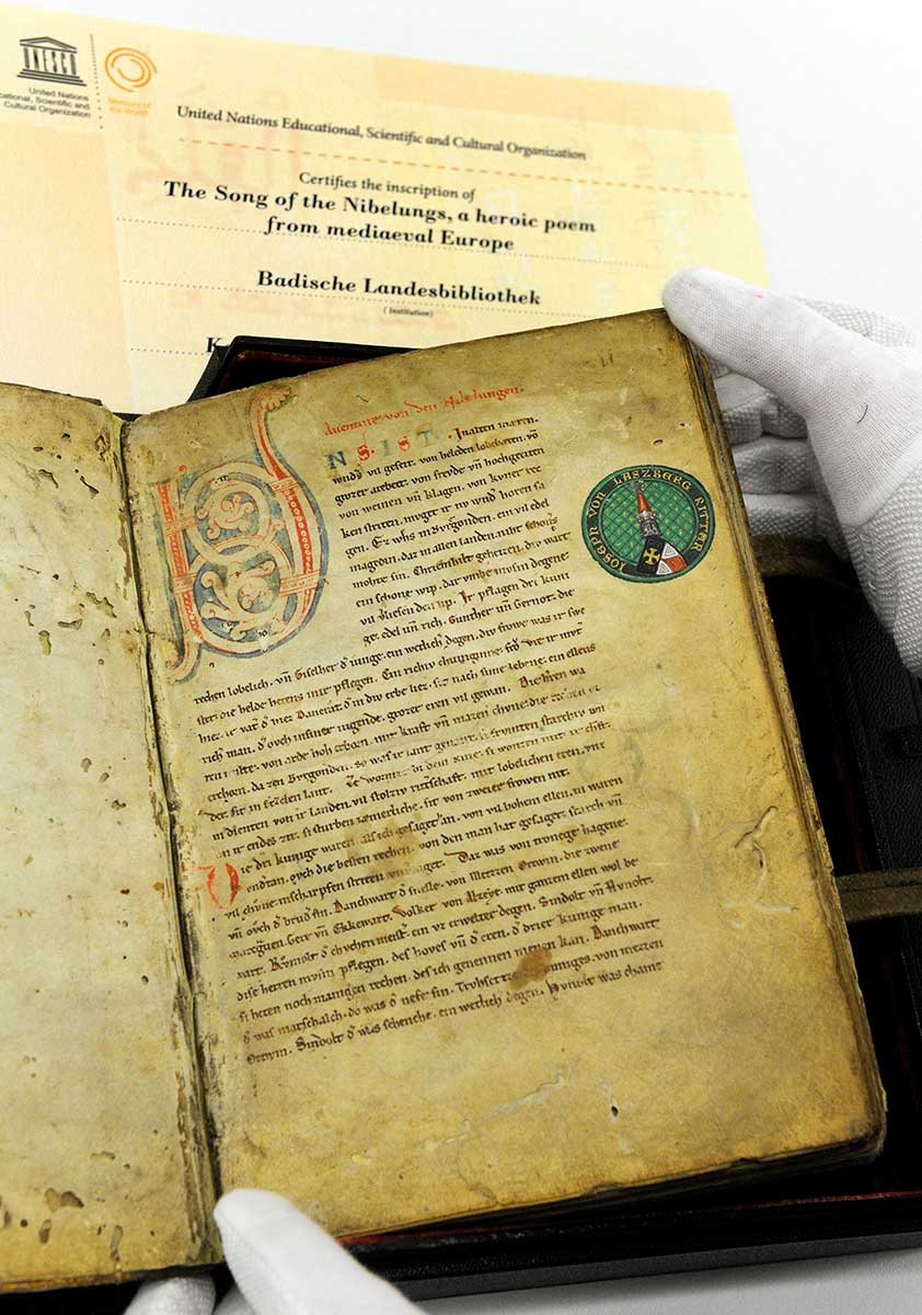 Zu sehen ist die erste Seite der Nibelungenliedhandschrift C mit dem Wappenexlibris des Joseph von Laßberg.