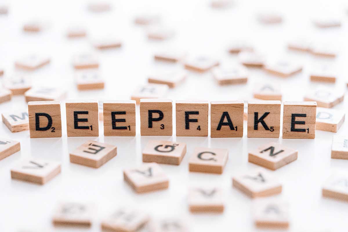 Zu sehen sind Spielsteine von Scrabble, die das Wort „Deepfake“ zeigen