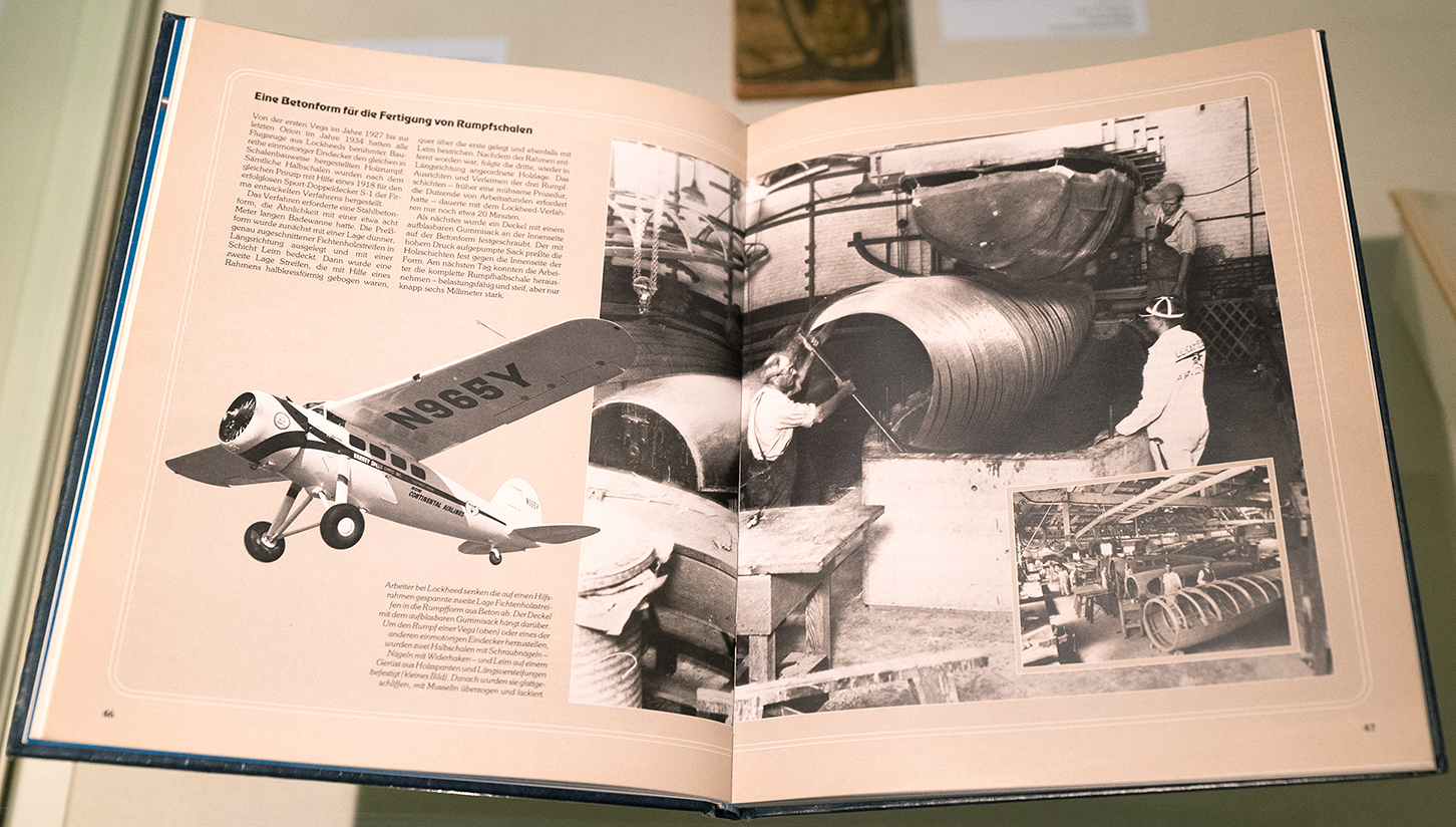 Geöffnetes Buch mit Schwarz-Weiß-Fotografien von Konstrukteuren beim Flugzeugbau