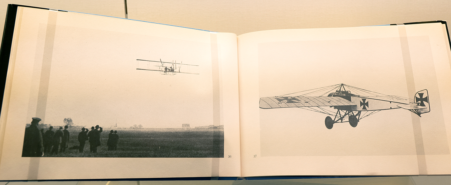 Aufgeschlagenes Buch mit ganzseitigen Schwarz-Weiß-Fotografien von Flugzeugen in der Luft