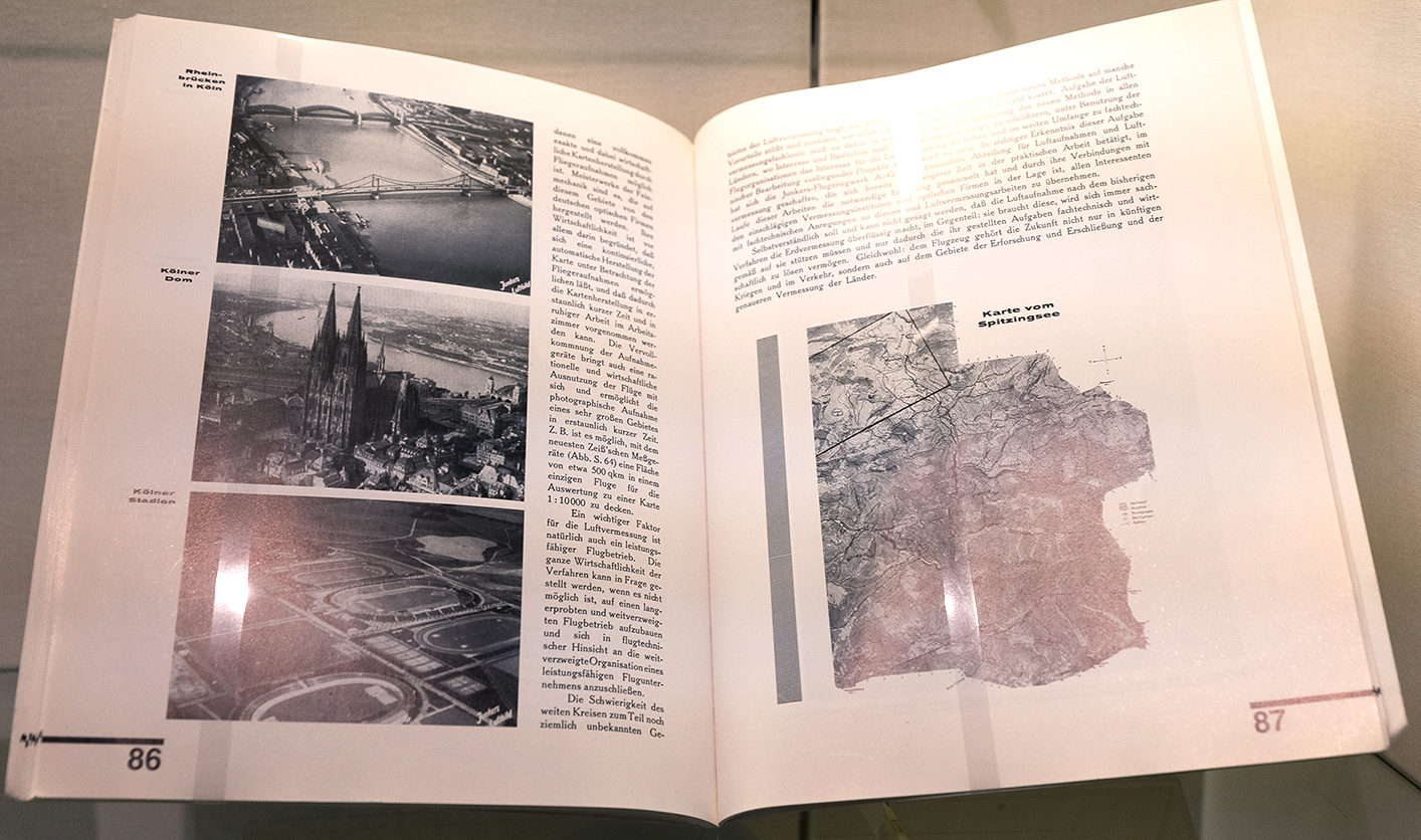 Geöffnetes Buch; links: Schwarz-Weiß-Luftbilder deutscher Städte; rechts: Landkarte