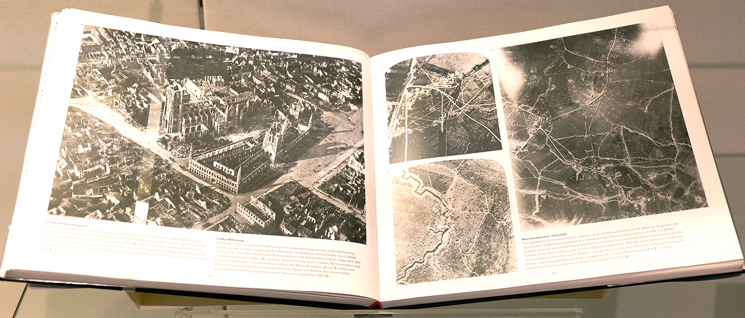 Aufgeschlagenes Buch; links: Schwarz-Weiß-Luftbild einer zerbombten Stadt; rechts: Schwarz-Weiß-Luftbilder