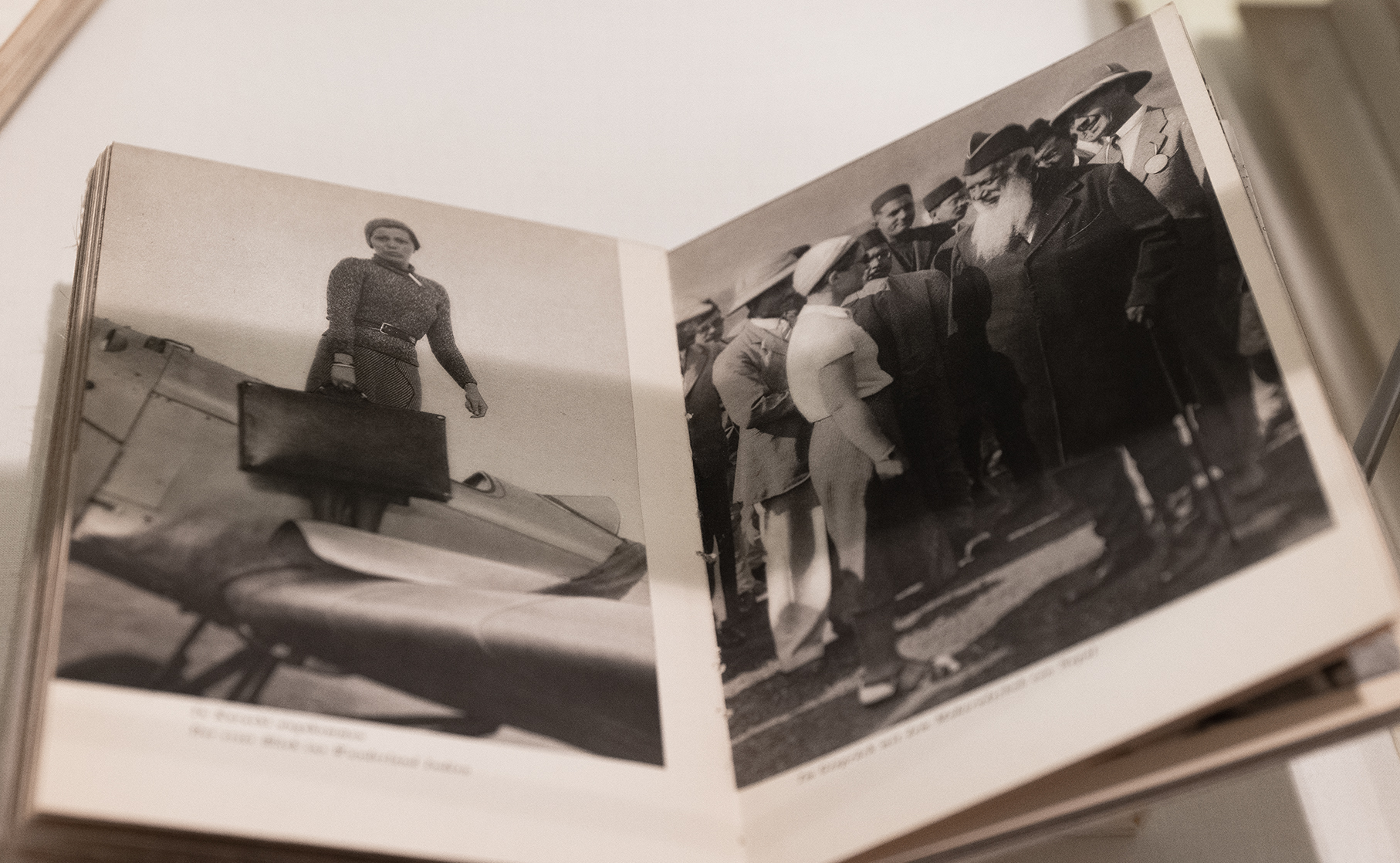 Geöffnetes Buch; links: Schwarz-Weiß-Porträt einer Pilotin; rechts: Schwarz-Weiß-Gruppenfoto