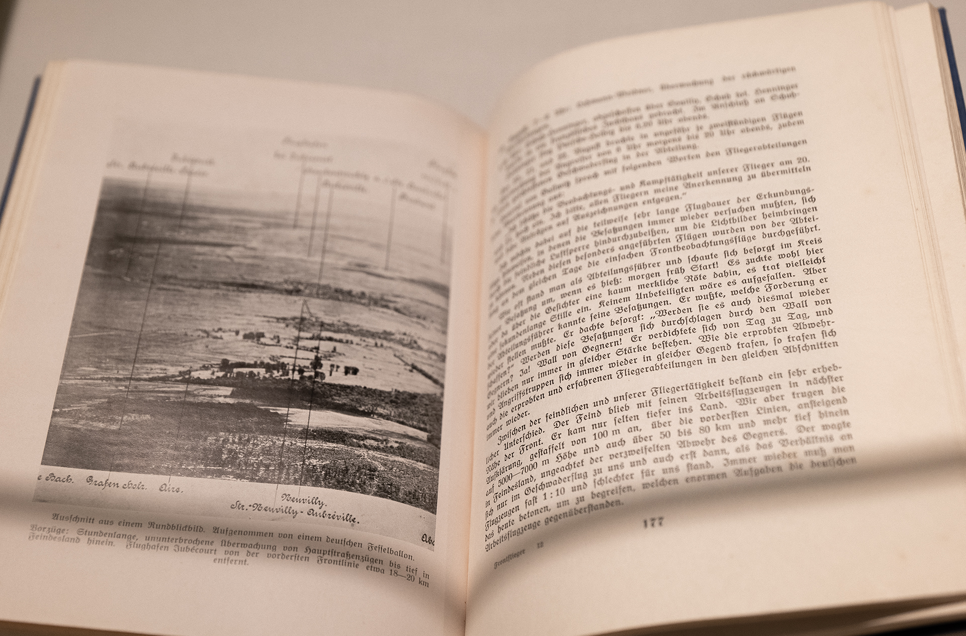 Geöffnetes Buch mit Schwarz-Weiß-Luftbild einer Landschaft