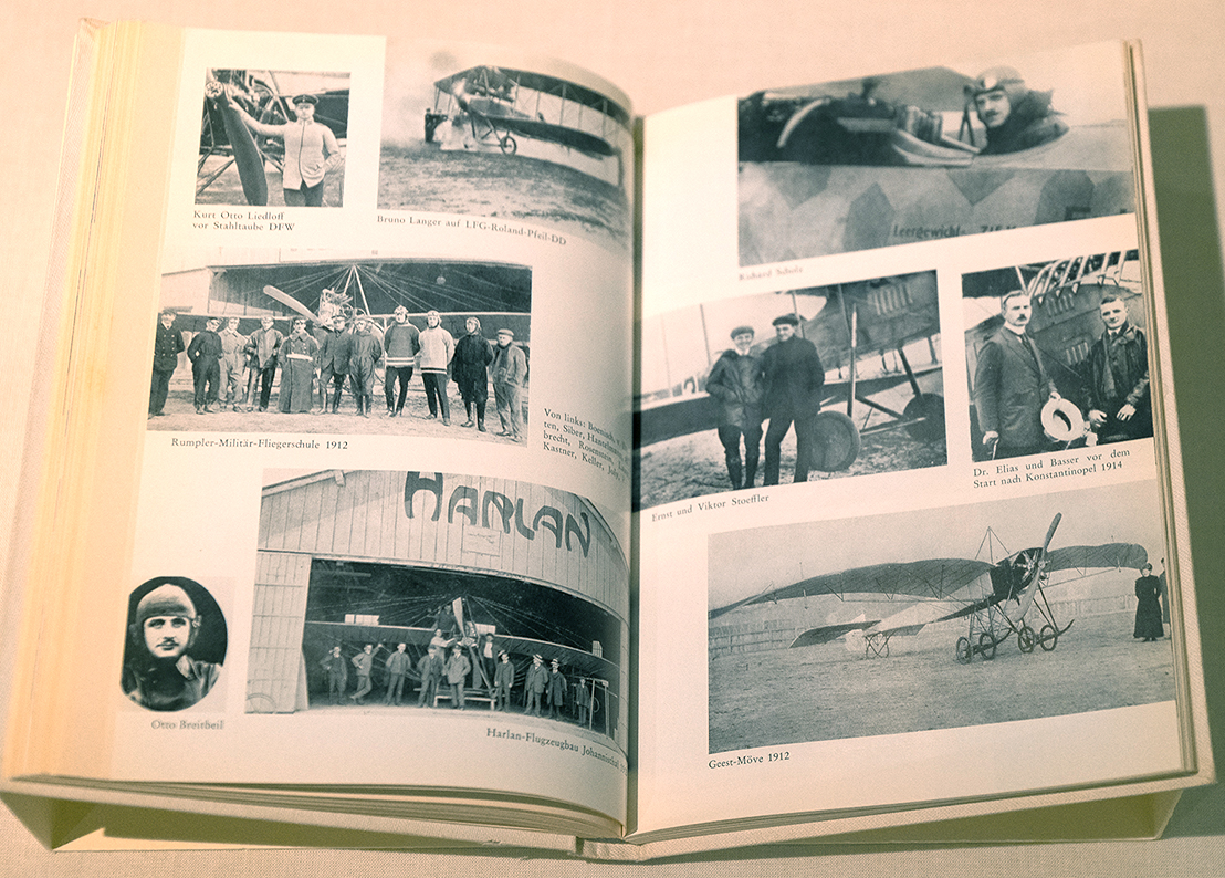 Aufgeschlagenes Buch mit verschiedenen Schwarz-Weiß-Porträts und Gruppenbildern