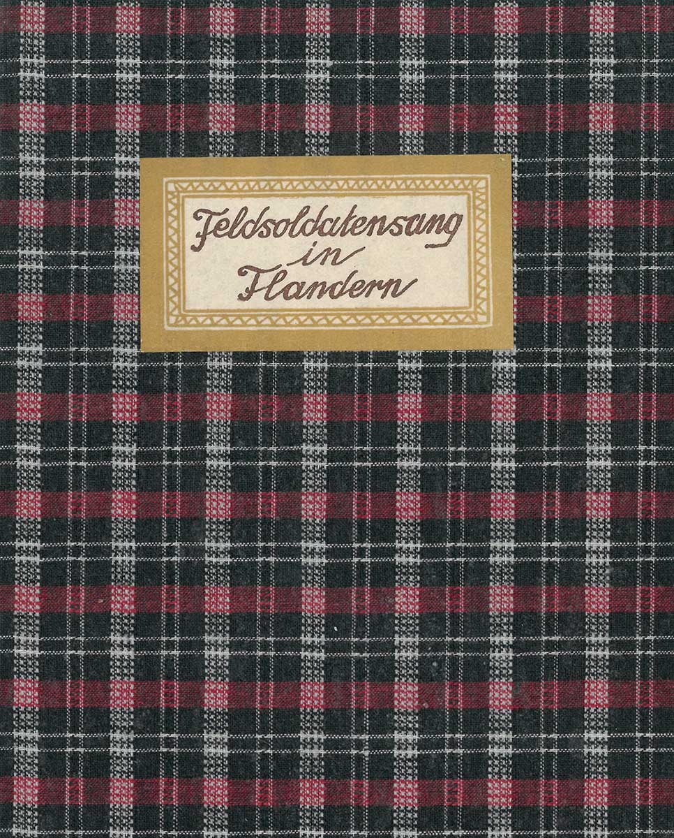 Zu sehen ist ein karierter Buchumschlag. Auf diesem klebt ein Etikett auf dem „Feldsoldatensang in Flandern“ steht. 