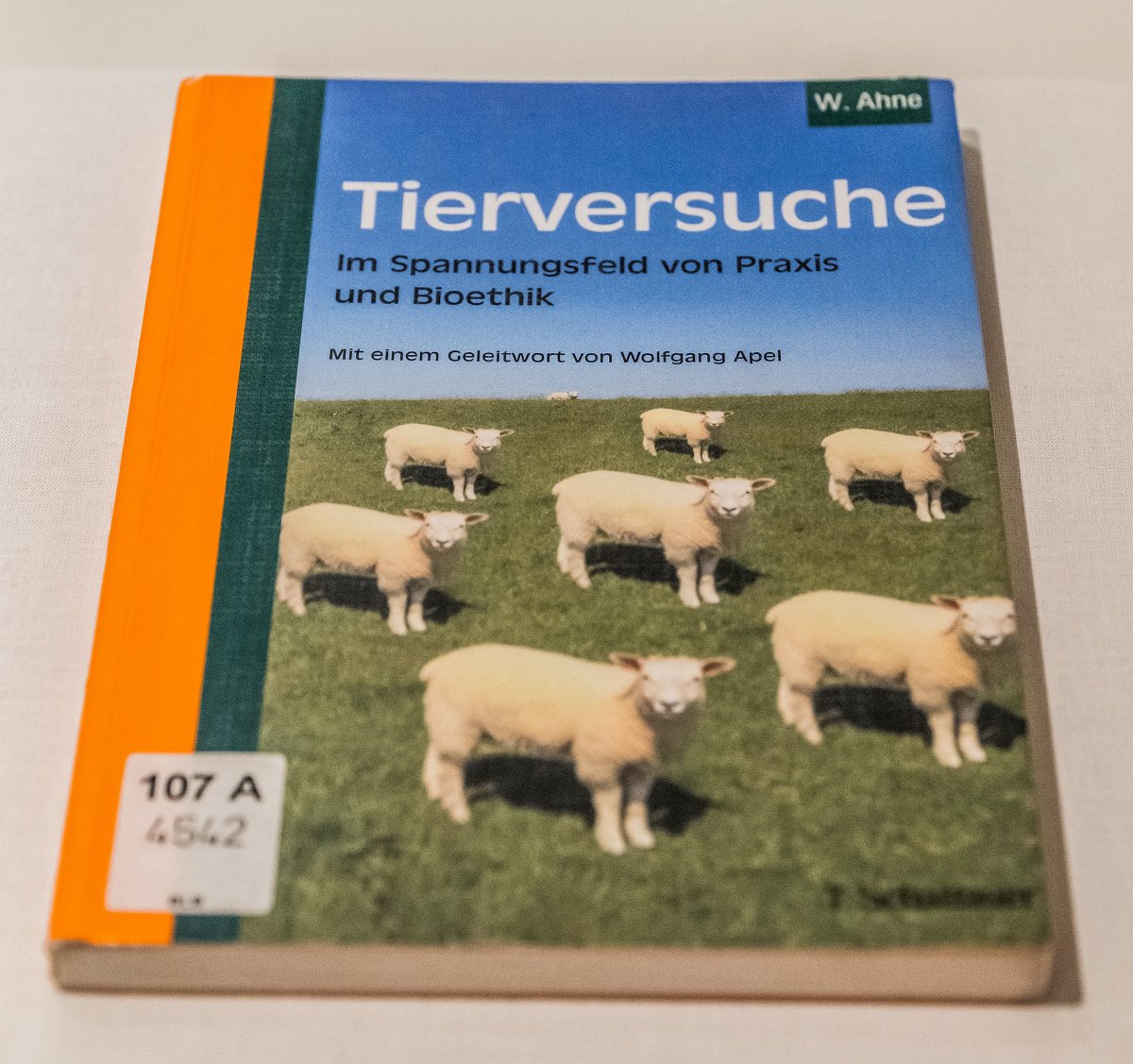 Einband des Buches „Tierversuche“. Auf dem Cover ist ein Foto von acht identisch aussehenden Schafen, die alle gleich auf einer Wiese stehen, zu sehen.