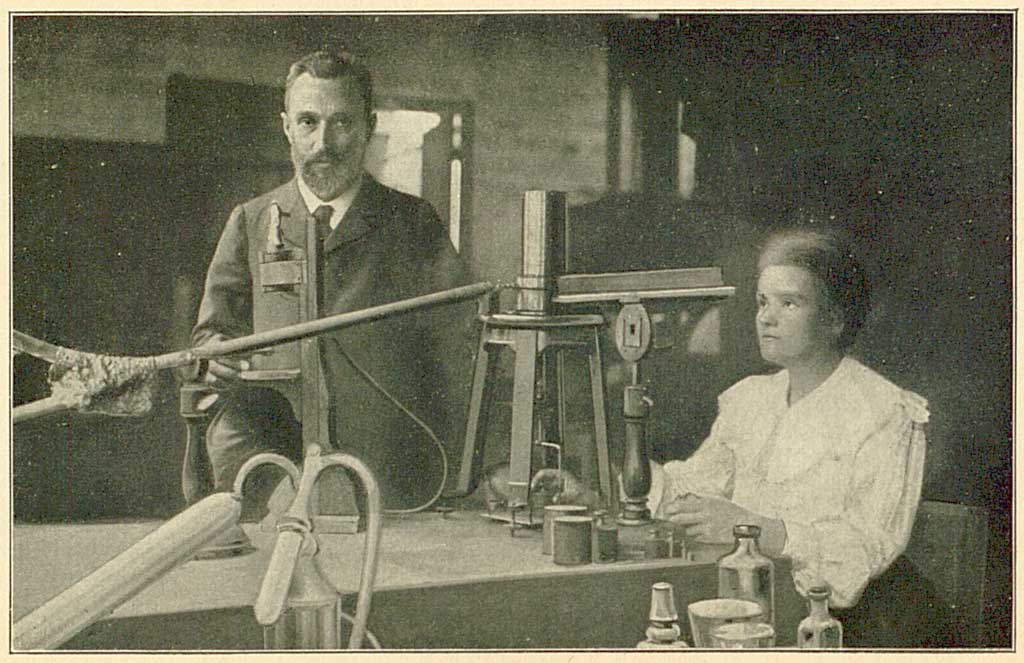 © Badische Landesbibliothek Karlsruhe Die Abbildung zeigt Pierre und Marie Curie in ihrem Labor. Pierre steht hinter einem Labortisch, während Marie an dem Tisch mit Forschungen beschäftigt ist.