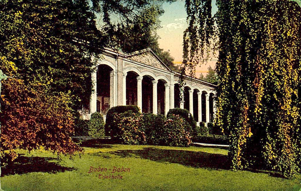 © Badische Landesbibliothek Karlsruhe Das Bild zeigt eine kolorierte Postkarte mit der Teilansicht der Schaufassade der Trinkhalle Baden-Baden samt vorgelagerter Parkanlage.