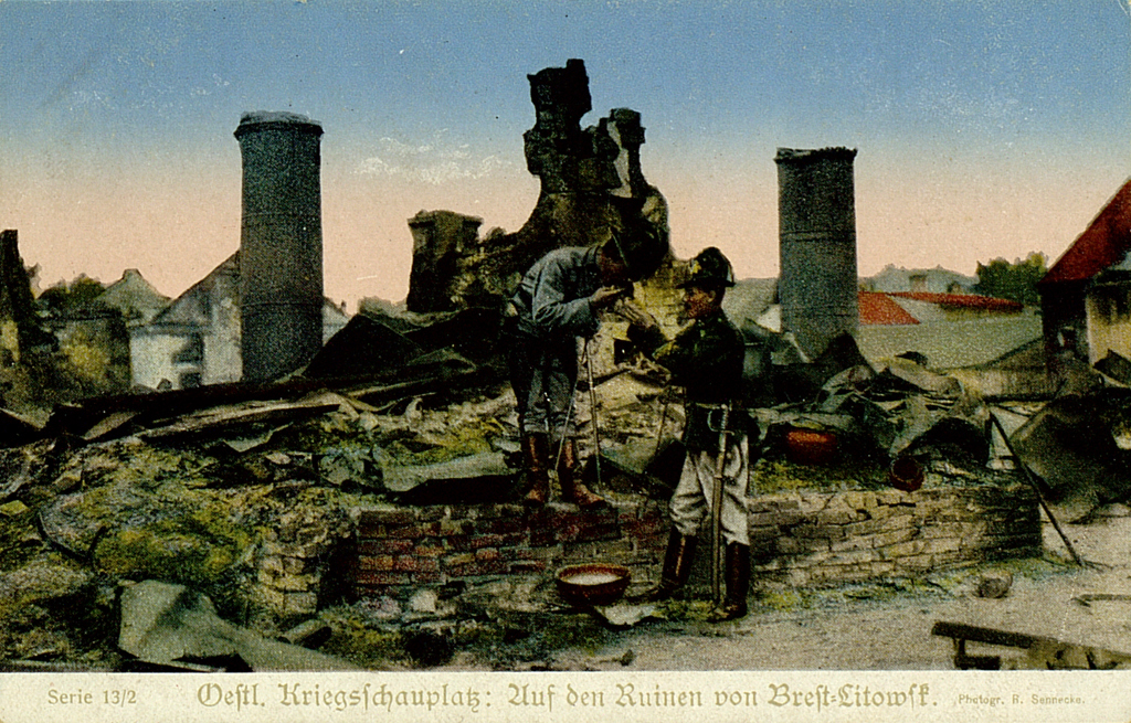 Die kolorierte Bildpostkarte zeigt zwei Soldaten in Ausgehuniform in den Ruinen von Best-Litowsk.
