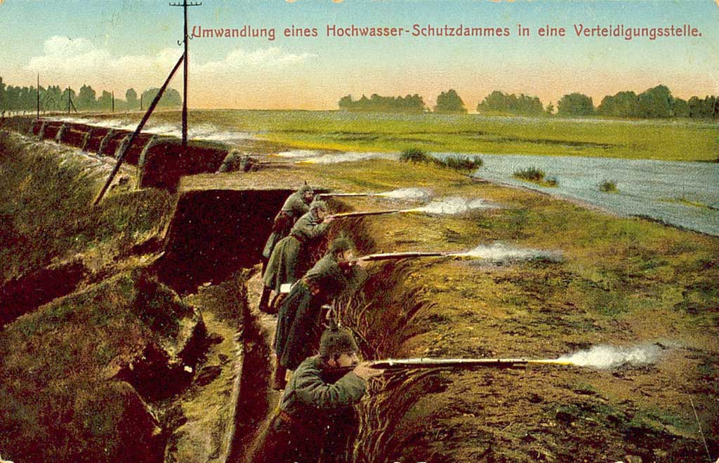 © Badische Landesbibliothek Karlsruhe Zu sehen ist ein Hochwasserschutzdamm der auf der einen Seite mit einem Schützengraben versehen wurde. Darin stehen mehrere Soldaten und feuern ihre Gewehre ab. Zu lesen ist: "Umwandlung eines Hochwasser-Schutzdammes in eine verteidigungsstelle".