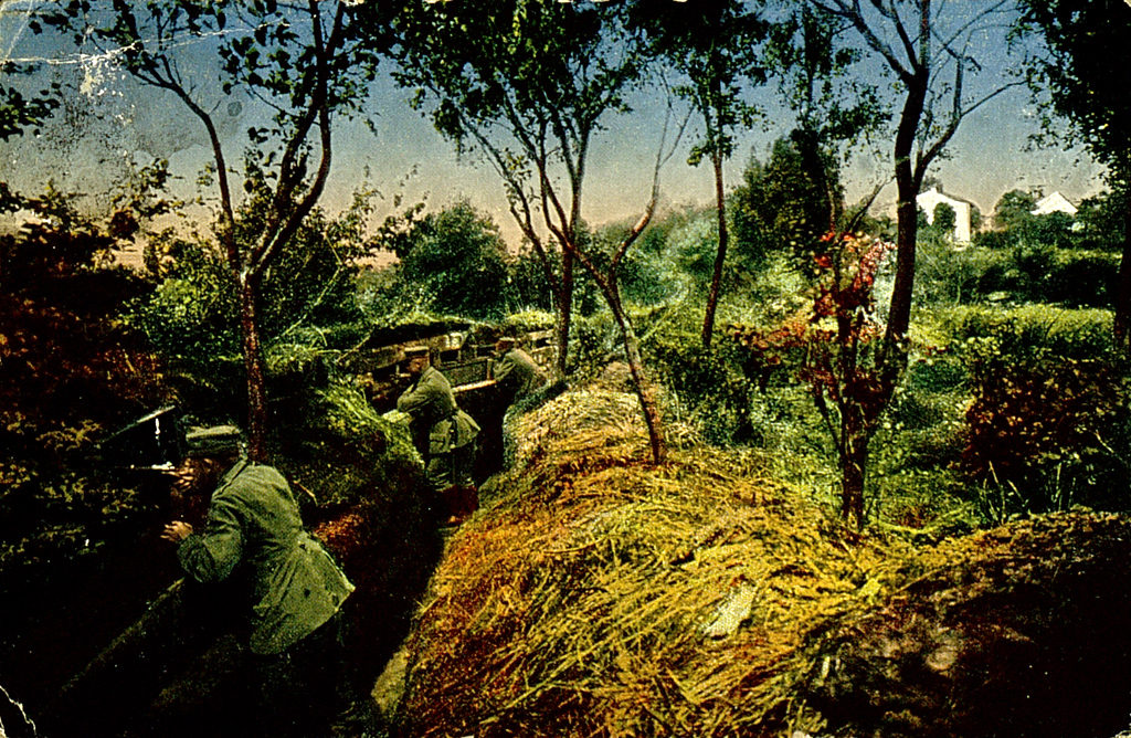 Die Aufnahme des Kriegsfotografen Max Wipperling zeigt Schützengräben am Rand eines Dorfes.  