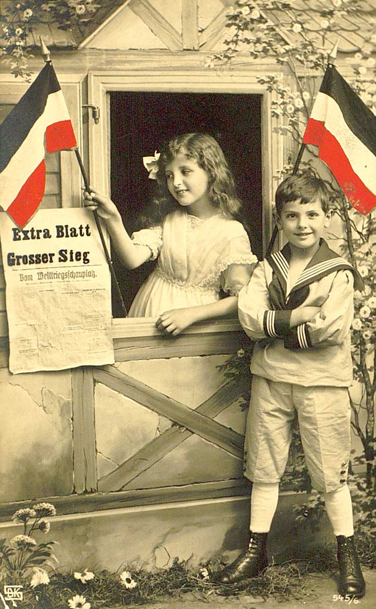 © Badische Landesbibliothek Karlsruhe Handkolorierte Foto-Postkarte mit Kindern mit Reichsfahnen und einer Zeitung "Extra Blatt. Grosser Sieg"