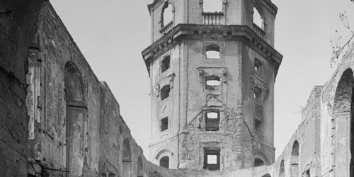 Zu sehen ist eine Schwarz-Weiß-Fotografie, welche eine zerstörte Ruine zeigt.