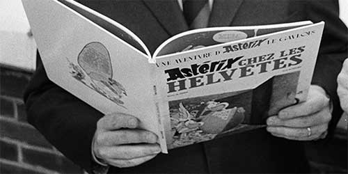 Person hält das Buch 'Asterix chez les Helvètes' mit sichtbarem Titel und Comicillustration auf dem Cover.