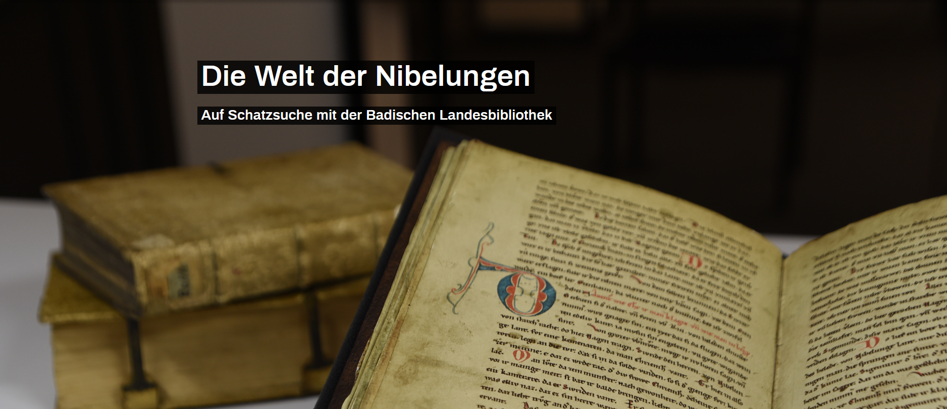 Zu sehen ist eine Detailansicht des Nibelungenliedes, sowie weitere Bücher. Der beinhaltete Text lautet: "Die Welt der Nibelungen. Auf Schatzsuche mit der Badischen Landesbibliothek". 