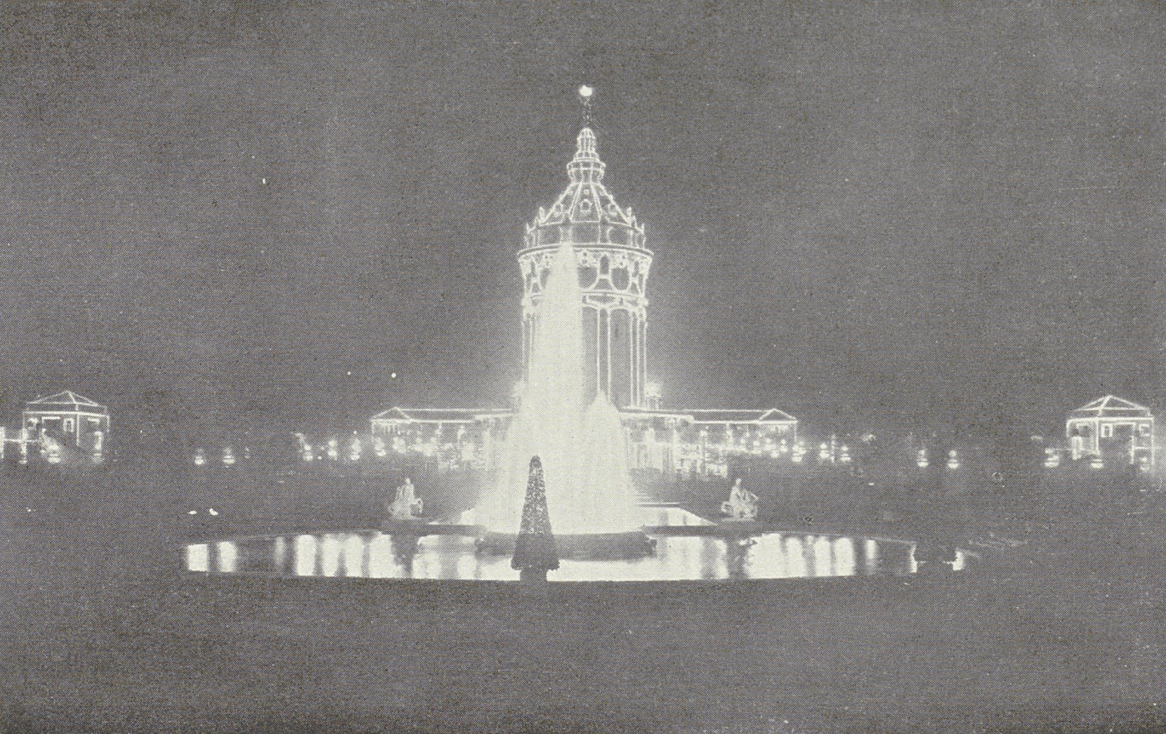 Das Foto zeigt die Konturenbeleuchtung und eine Leuchtfontäne am Wasserturm der Internationalen Kunst- und Gartenbauausstellung in Mannheim 1907.