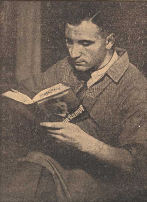 Zu sehen ist eine schwarz-weiße Aufnahme eines Mannes, der in einem Exemplar von „Mein Kampf“ liest.