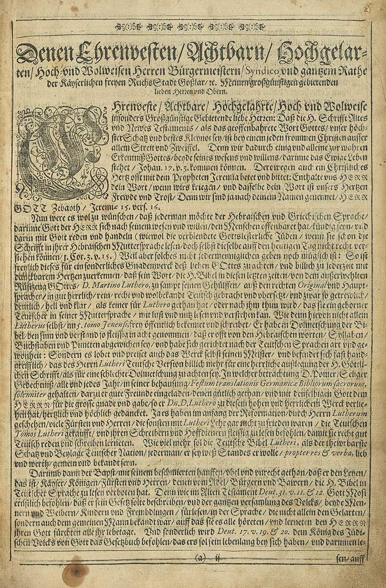 Zu sehen ist eine Seite aus der Bibel, samt verzierter Kapitalinitiale.
