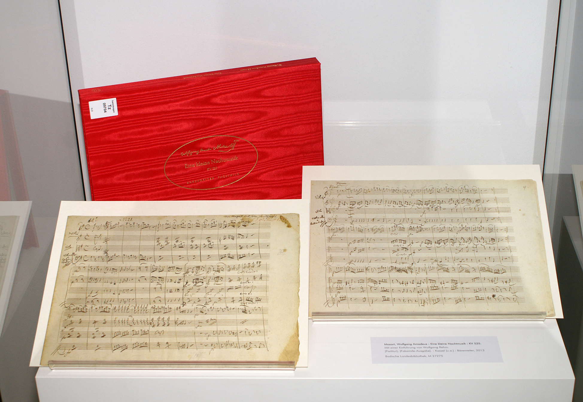 Ausstellungsansicht von Mozart's "Eine kleine Nachtmusik", der Einband ist rot mit goldenem Titel.